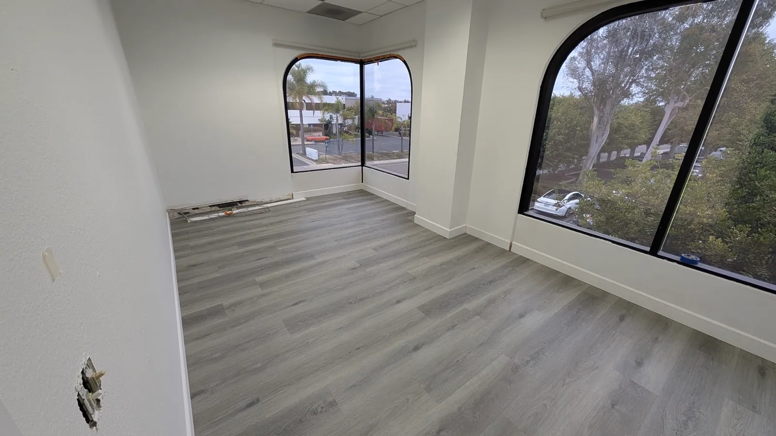 The same space with new flooring laid and partitions closed up